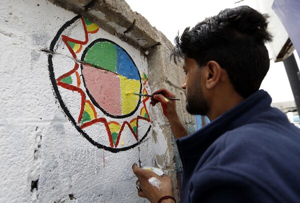 فنان يمني يرسم لوحة غرافيتي على الجدران لدعم السلام، في إطار حملة يوم مفتوح للفن في العصامة صنعاء، اليمن 15 مارس/ آذار 2018 - سبوتنيك عربي