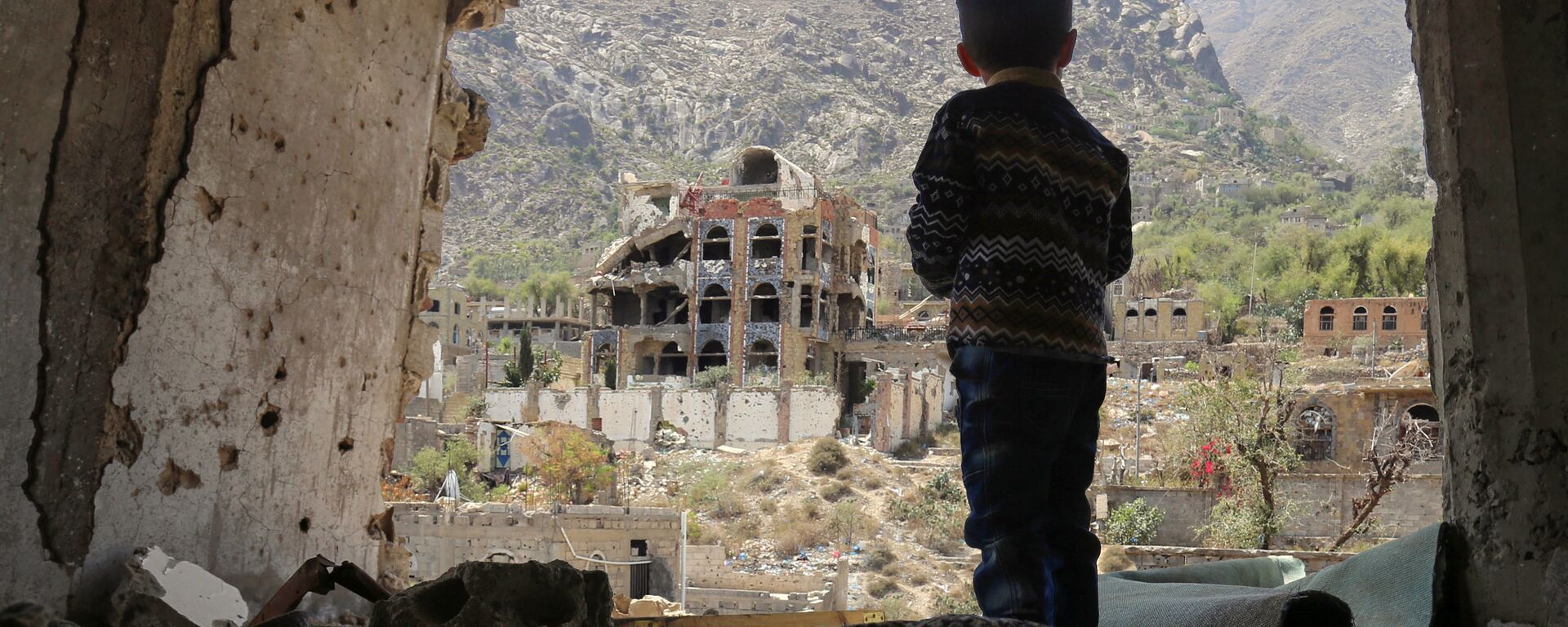 صبي صغير يقف على خلفية ركام في تعز، اليمن 18 مارس/ آذار 2018 - سبوتنيك عربي, 1920, 19.09.2022