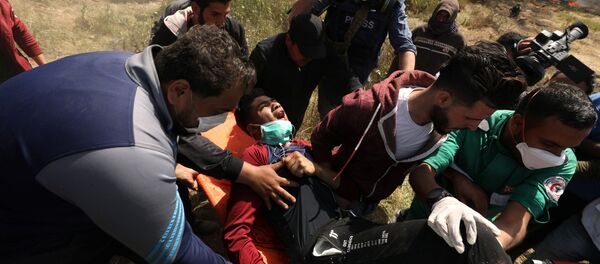 جرحى ومصابين خلال الاشتباكات بين الفلسطينيين والجنود الإسرائيليين على حدود قطاع غزةفي جمعة الكوشوك، مسيرة العودة،، فلسطين، 6 أبريل/ آذار 2018 - سبوتنيك عربي