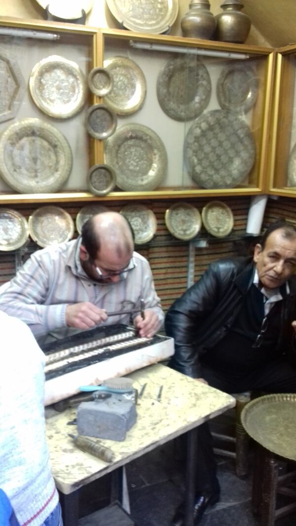 حرفيون يقومون بتطعيم النحاس في إحدى الورش بمدينة دمشق حرفيون يقومون بتطعيم النحاس في إحدى الورش بمدينة دمشق - سبوتنيك عربي