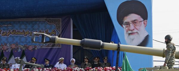 دبابة تابعة للجيش الإيراني تمر من جانب المنبر المزين بصورة للزعيم الإيراني الأعلى آية الله علي خامنئي خلال استعراض بمناسبة يوم الجيش السنوي للبلاد، 18 أبريل/نيسان 2018 في طهران. - سبوتنيك عربي