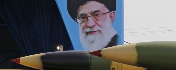 شاحنة عسكرية إيرانية تحمل صواريخ أرض جو أمام لوحة للزعيم الإيراني الأعلى آية الله علي خامنئي خلال استعراض بمناسبة عيد الجيش الإيراني السنوي في 18 أبريل/نيسان 2018 في طهران.  - سبوتنيك عربي