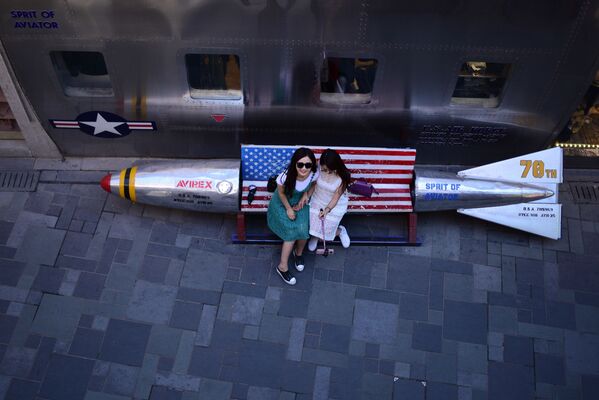 امرأتان تلتقطان صورة على مقعد له شكل صاروخ خارج أحد المتاجر في بكين، الصين 3 مايو/ أيار 2018 - سبوتنيك عربي