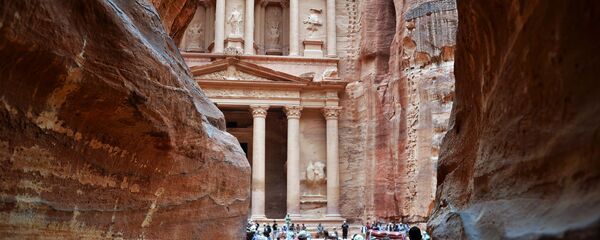السائحون يزورون مقابر البتراء بالمعبد الصخري في الخازن (خزنة الفرعون) في مدينة البتراء القديمة في الأردن. - سبوتنيك عربي