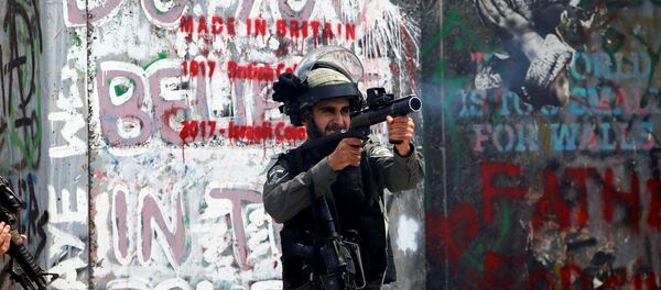 شرطي الحدود الإسرائيلي يطلق الغاز المسيل للدموع على المتظاهرين الفلسطينيين في بيت لحم خلال احتجاجات ضد نقل السفارة الأمريكية إلى القدس عشية الذكرى الـ 70 لـ النكبة، الضفة الغربية، فلسطين 14 مايو/ أيار 2018 - سبوتنيك عربي