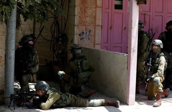 جنود إسرائليون يقنصون المتظاهرين الفلسطينيين عند حاجز قلنديا، جنوب رام الله، خلال احتجاجات ضد نقل السفارة الأمريكية إلى القدس عشية الذكرى الـ 70 للنكبة، الضفة الغربية، فلسطين 14 مايو/ أيار 2018 - سبوتنيك عربي