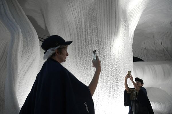 زوار يلتقطون الصور في الكهف الجليدي في حديقة زارياديا بجوار الكرملين في موسكو - سبوتنيك عربي