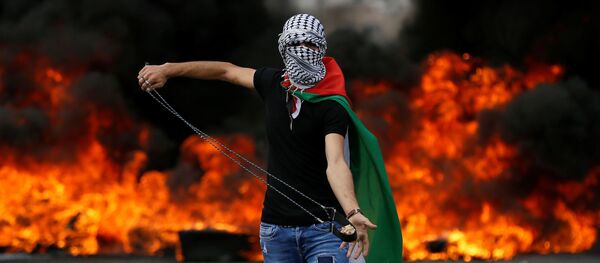 شاب فلسطيني خلال مسيرات العودة الكبرى واحياء الذكرى الـ70 للنكبة بالقرب من مستوطنة يهودية في بيت إيل، بالقرب من رام الله، الضفة الغربية 15 مايو/ أيار 2018 - سبوتنيك عربي