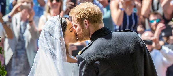 نجل ولي عهد بريطانيا الأمير هاري يقبل عروسه ميغان ماركل في حفل زفافهما، 19 مايو/أيار 2018 - سبوتنيك عربي
