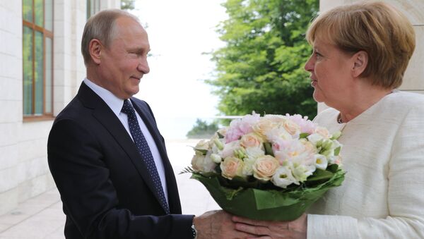 الرئيس فلاديمير بوتين يهدي باقة من الأزهار لمستشارة ألمانيا أنجيلا ميركل لدى وصولها مدينة سوتشي، روسيا 20 مايو/ أيار 2018 - سبوتنيك عربي