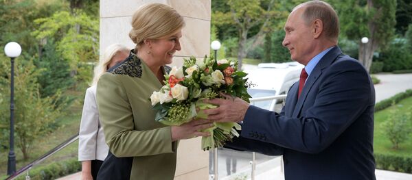 الرئيس الروسي فلاديمير بوتين يهدي باقة من الأزهار لرئيسة لرئيسة جمهورية كرواتيا كوليندا غرابر-كيتاروفيتش لدى وصولها إلى سوتشي، 2018 - سبوتنيك عربي