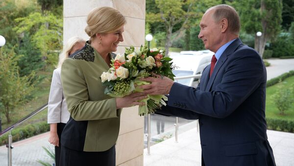 الرئيس الروسي فلاديمير بوتين يهدي باقة من الأزهار لرئيسة لرئيسة جمهورية كرواتيا كوليندا غرابر-كيتاروفيتش لدى وصولها إلى سوتشي، 2018 - سبوتنيك عربي
