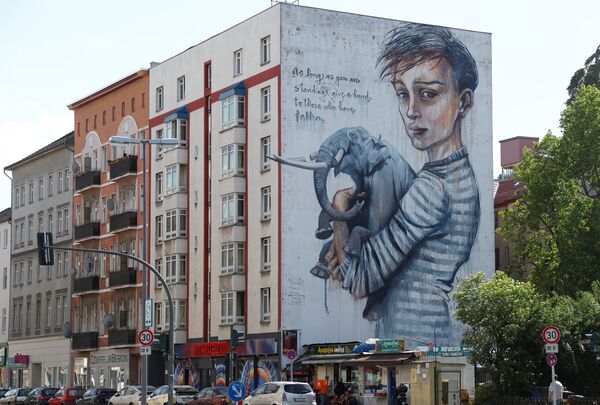 رسم غرافيتي لعدد من الفنانين أونور وويس21 وهيركاوت (Onur،  Wes21 ، Herakut ) ، كجزء من مهرجان برلين للجداريات 2018 الأول من نوعه، حيث يقوم الفنانون المدنيون المحليون والدوليون بإنشاء معرض كبير في الهواء الطلق لإثراء المساحات الحضرية في برلين، ألمانيا 21 مايو/ أيار 2018 - سبوتنيك عربي