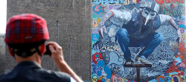 جدارية للفنان كولابو واند (Kollabo Wand) كجزء من مهرجان برلين للجداريات 2018 الأول من نوعه، حيث يقوم الفنانون المدنيون المحليون والدوليون بإنشاء معرض كبير في الهواء الطلق لإثراء المساحات الحضرية في برلين، ألمانيا  21 مايو/ أيار 2018 - سبوتنيك عربي