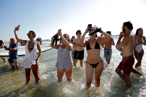 المصطافون على الشاطئ يلتقطون صور لنجل ولي عهد بريطانيا الأمير وليام خلال أول زيارة ملكية له لإسرائيل، 26 يونيو/حزيران 2018 - سبوتنيك عربي