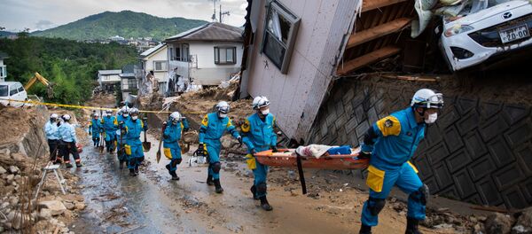 وصول طواقم الانقاذ ورجال الشرطة لاتمام عمليات الانقاذ في منطقة كومانو، هيروشيما، اليابان 9 يوليو/ تموز 2018 - سبوتنيك عربي