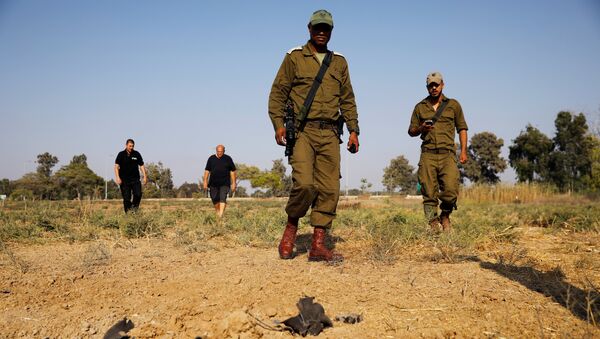عساكر إسرائيليون يتفحصون أماكن سقوط قذائف على الحدود الإسرائيلية مع غزة، السبت 14 يوليو/تموز 2018 - سبوتنيك عربي
