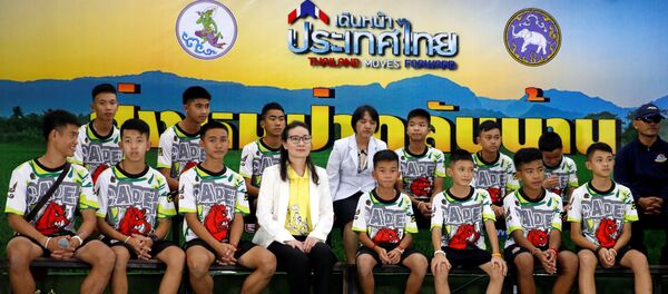 الصبية التايلانديين الـ 12 مع مدربهم في مؤتمر صحفي في  تايلاند بعد إنقاذهم من الكهف، 18 يوليو/تموز 2018 - سبوتنيك عربي