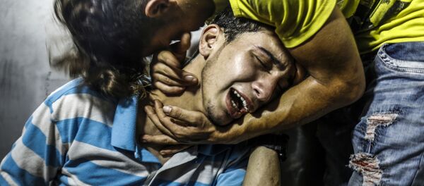 شباب فلسطينيون يبكون شابين قتلا في غارة جوية إسرائيلية في مدينة غزة، قطاع غزة، فلسطين 14 يوليو/ تموز 2018 - سبوتنيك عربي