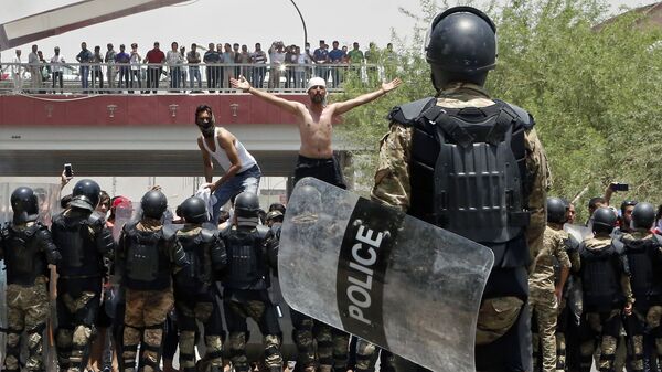 شرطة مكافحة الشغب العراقية تمنع المحتجين من اقتحام مبنى مجلس المحافظة خلال مظاهرة في البصرة، على بعد 550 كم جنوب شرق بغداد، العراق  15 يوليو/ تموز2018 - سبوتنيك عربي