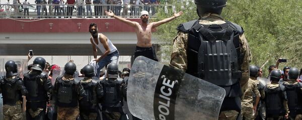 شرطة مكافحة الشغب العراقية تمنع المحتجين من اقتحام مبنى مجلس المحافظة خلال مظاهرة في البصرة، على بعد 550 كم جنوب شرق بغداد، العراق  15 يوليو/ تموز2018 - سبوتنيك عربي