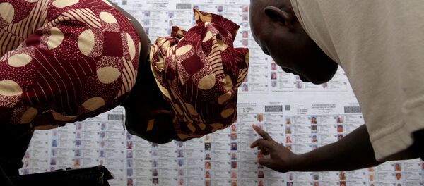 أشخاص يبحوث عن أسمائهم في القائمة الانتخابية في مركز الاقتراع في لافيابوغو، باماكو، مالي 23 يلويو/ تموز 2018 - سبوتنيك عربي