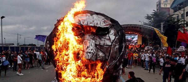 ناشطون يحرقون تمثالًا للرئيس الفلبيني رودريغو دوتيرتي لدى إلقائه خطابا حول حالة الأمة في مجلس النواب في مدينة كيزون-سيتي، مانيلا، الفلبين 23 يوليو/ تموز 2018 - سبوتنيك عربي