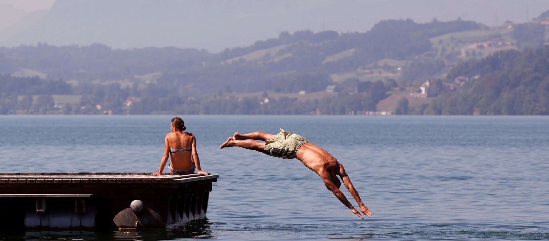 رجل يقفز الرجل في بحيرة زوغ في سويسرا هربا من حر الصيف - سبوتنيك عربي, 1920, 03.08.2018