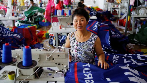 عاملة صينية في مصنع لتصنيع أعلام حملة إعادة انتخاب الرئيس الأمريكي دونالد ترامب في عام 2020 - سبوتنيك عربي