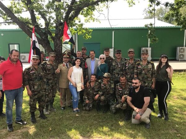 السفير السوري بموسكو الدكتور رياض حداد مع أفراد من الجالية والشخصيات الرسمية خلال حضورهم عروض سباق بياتلون الدبابات بدورة الألعاب العسكرية في موسكو - سبوتنيك عربي