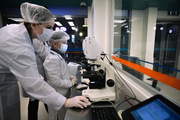 موظف وصبي في مركز تعليمي كيدزانيا (Кидзания) لاستخدام أجهزة المختبر داخل المستشفيات في موسكو - سبوتنيك عربي