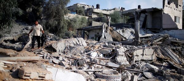 رجل فلسطيني يتفقد موقعا تابعا لـ حماس بعد القصف الجوي الإسرائيلي في منطقة المغراقة، ضواحي مدينة غزة، قطاع غزة، 9 أغسطس/ آب 2018 - سبوتنيك عربي