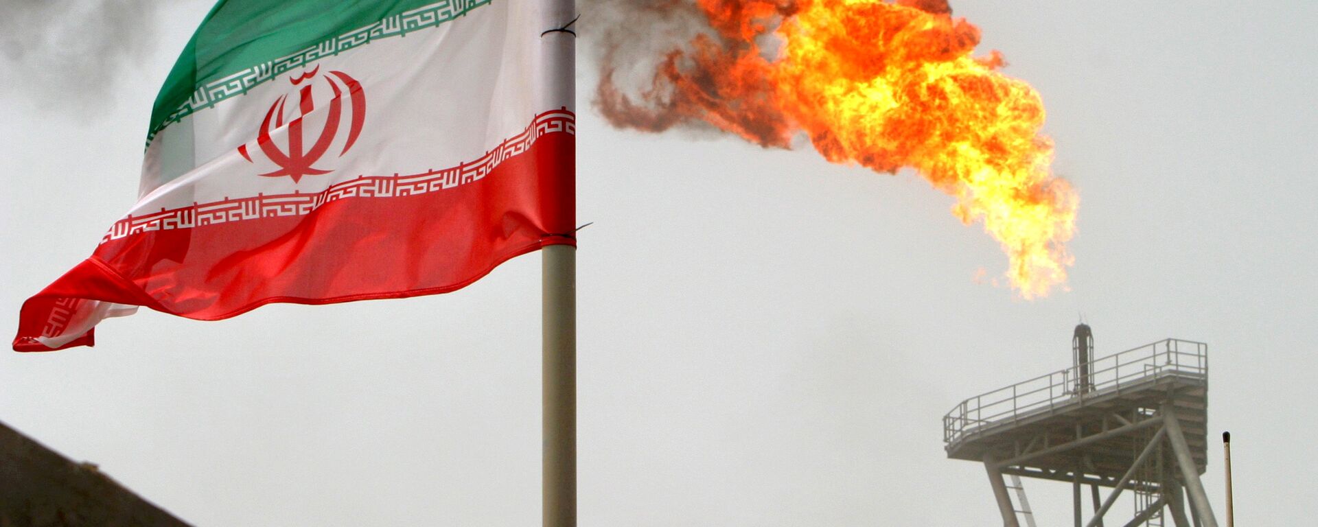 علم إيران على خلفية توهج ناري لغاز في حقل سوروش النفطي في الخليج الفارسي، إيران 25 يوليو/ تموز 2018 - سبوتنيك عربي, 1920, 01.05.2021