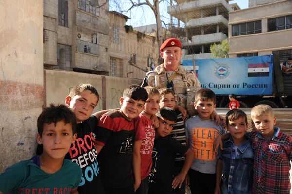 أطفال سوريون يلتقطون صورة جماعية مع عسكري روسي - سبوتنيك عربي