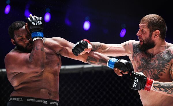 ألكسندر يميليانينكو (روسيا) وتوني جونسون (الولايات المتحدة) خلال مباراة الملاكمة في إطار بطولة العالم للفنون القتالية المختلطة في ملعب لوجنيكي، موسكو، روسيا 23 أغسطس/ آب 2018 - سبوتنيك عربي