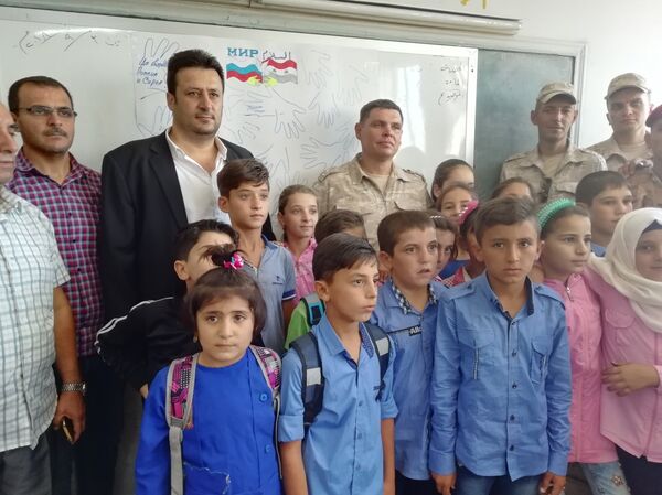 جنرال روسي وضباطه يشاركون أطفال قمحانة السورية يومهم الدراسي الأول - سبوتنيك عربي