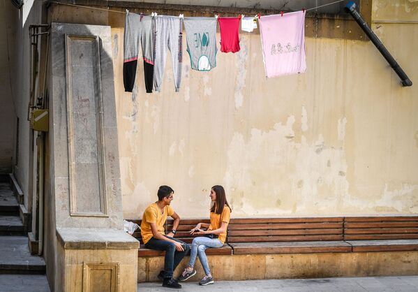أشخاص يافعون يجلسون في أحد وشارع مدينة باكو، آذربيجان 22 سبتمبر/ أيلول 2018 - سبوتنيك عربي