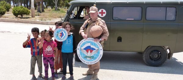 جندي من مركز المصالحة الروسي في سوريا مع اطفال سوريين  - سبوتنيك عربي