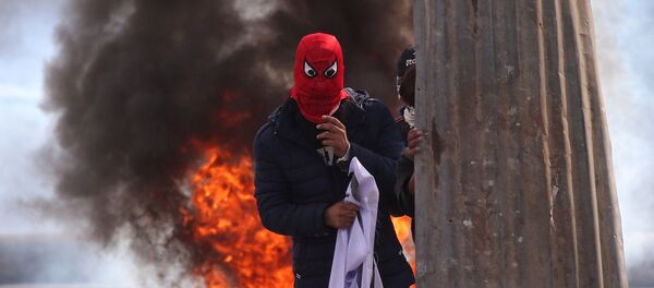 متظاهرون مقنعون من كشمير أمام عجلات مشتعلة بالقرب من موقع اشتباكات بين قوات الشرطة الهندية ومسلحين مشتبهين في سرينجار، 17 أكتوبر/ تشرين الأول 2018 - سبوتنيك عربي