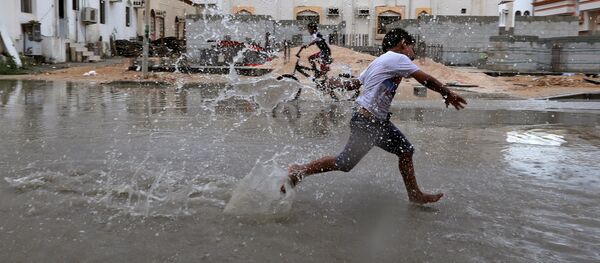 أطفال يلعبون بمياه الفياضانات بعد إعصار لبان في حي صلالة، عُمان 13 أكتوبر/ تشرين الأول 2018 - سبوتنيك عربي