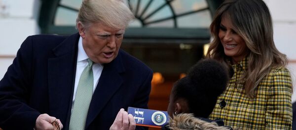 الرئيس الأمريكي دونالد ترامب وزوجته ميلانيا ترامب يوزعان الحلوى على الأطفال في عيد الهالوين، 28 أكتوبر/تشرين الأول 2018 - سبوتنيك عربي
