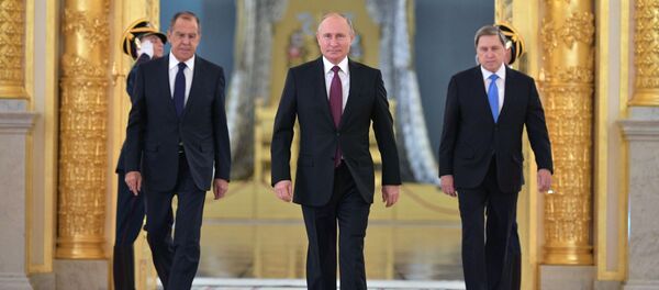 الرئيس فلاديمير بوتين ووزير الخارجية الروسي سيرغي لافروف والمساعد الرئاسي يوري أوشاكوف لدى وصولهم قاعة ألكسندر في الكرملين، لحضور مراسم اعتماد وقبول سفراء الدول الأجانب في موسكو - سبوتنيك عربي