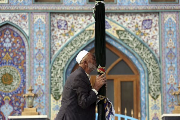 رجل أفغاني يقبل أحد أعمدة مكان ضريح كارته سخي في كابول، 30 أكتوبر/ تشرين الأول 2018 - سبوتنيك عربي