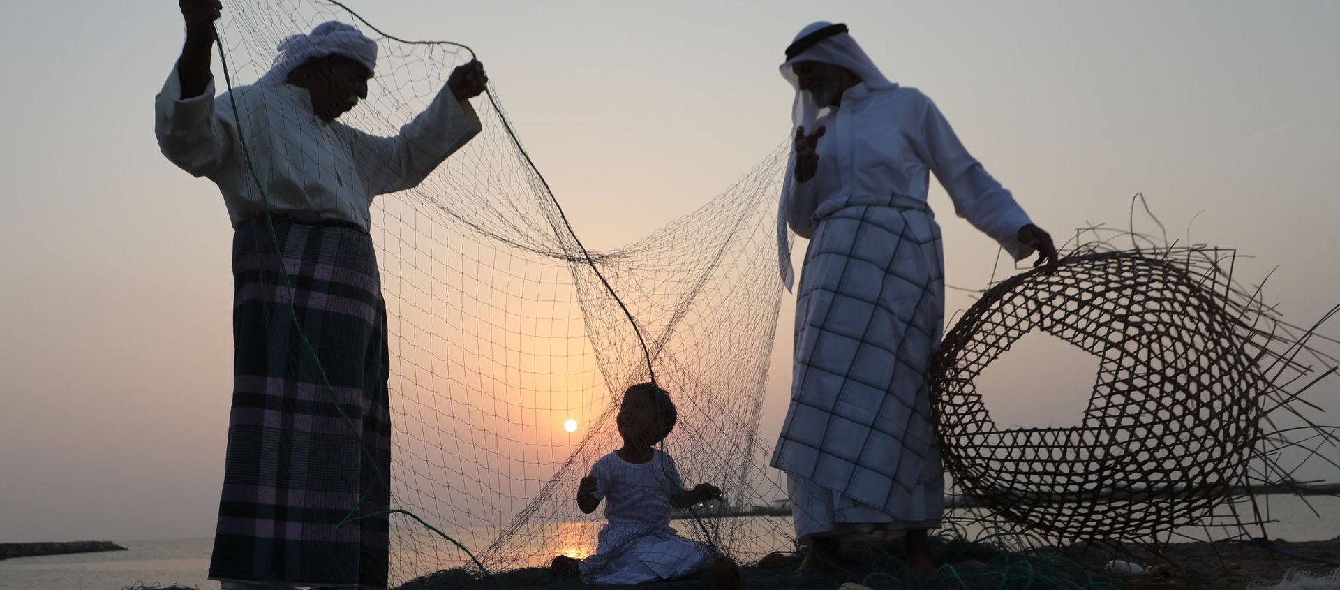 رجال إمارتيون يدربون طفلا على الحرف الصناعية اليدوية خلال مهرجان دلما البحري في الخريج العربي، 40 كم عن أبو ظبي، الإمارات المتحدة 27 أكتوبر/ تشرين الأول 2018 - سبوتنيك عربي, 1920, 13.07.2021