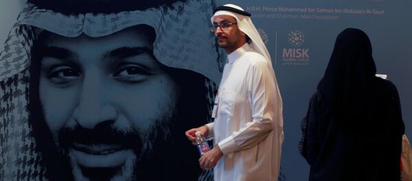 أحد المشاركين يسير بجوار صورة ولي العهد السعودي الأمير محمد بن سلمان خلال منتدى مسك العالمي في الرياض - سبوتنيك عربي