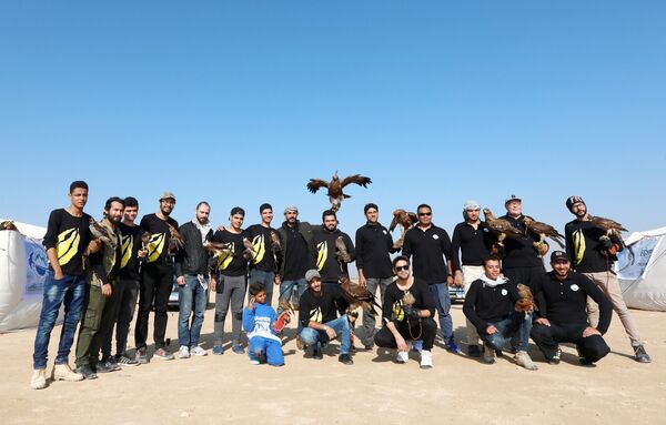 أعضاء من نادي إيجي فالكونر يلتقطون صورة فوتوغرافية لصقورهم خلال الاحتفال باليوم العالمي لصيد الصقور في صحراء برج العرب بالإسكندرية - سبوتنيك عربي