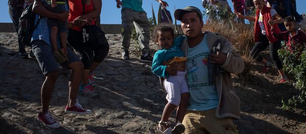 مهاجرين يحاولون اقتحام الحدود الأمريكية المكسيكية - سبوتنيك عربي