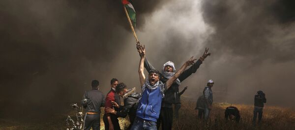 صورة العام لـ2018: متظاهرون فلسطينيون يصرخون خلال مواجهات مع القوات الإسرائيلية في مظاهرة مطالبين بحق العودة إلى وطنهم على الحدود بين إسرائيل وشرق مدينة غزة - سبوتنيك عربي