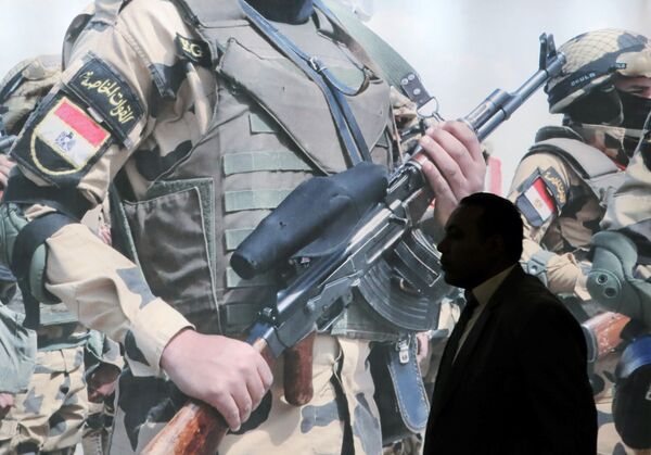 زائر يسير على خلفية منشرو للجيش المصري معرض إيديكس 2018 في القاهرة، 3 ديسمبر/ كانون الأول 2018 - سبوتنيك عربي