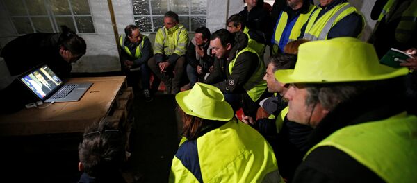 متظاهرون تابعون لحركة السترات الصفراء يشاهدون كلمة الرئيس الفرنسي داخل الخيام - سبوتنيك عربي